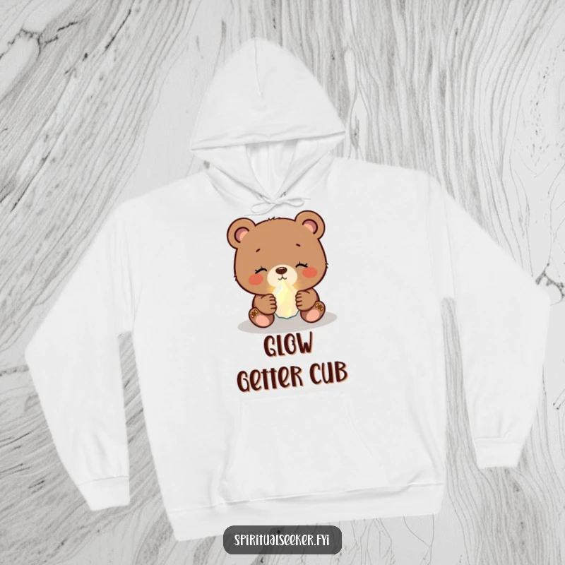 Funny bear cub hoodie depicting a serene cub holding a small, glowing crystal, offering warmth and humor.