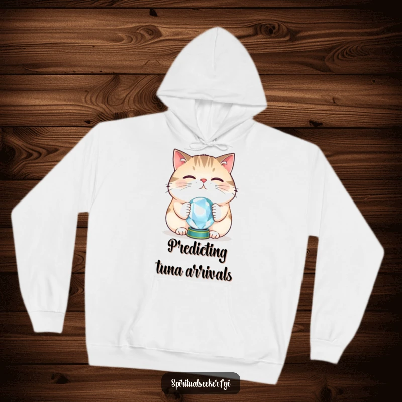 Funny cat hoodie depicting a plump feline balancing a crystal ball on its nose, offering warmth and a dose of playful, mystic humor.